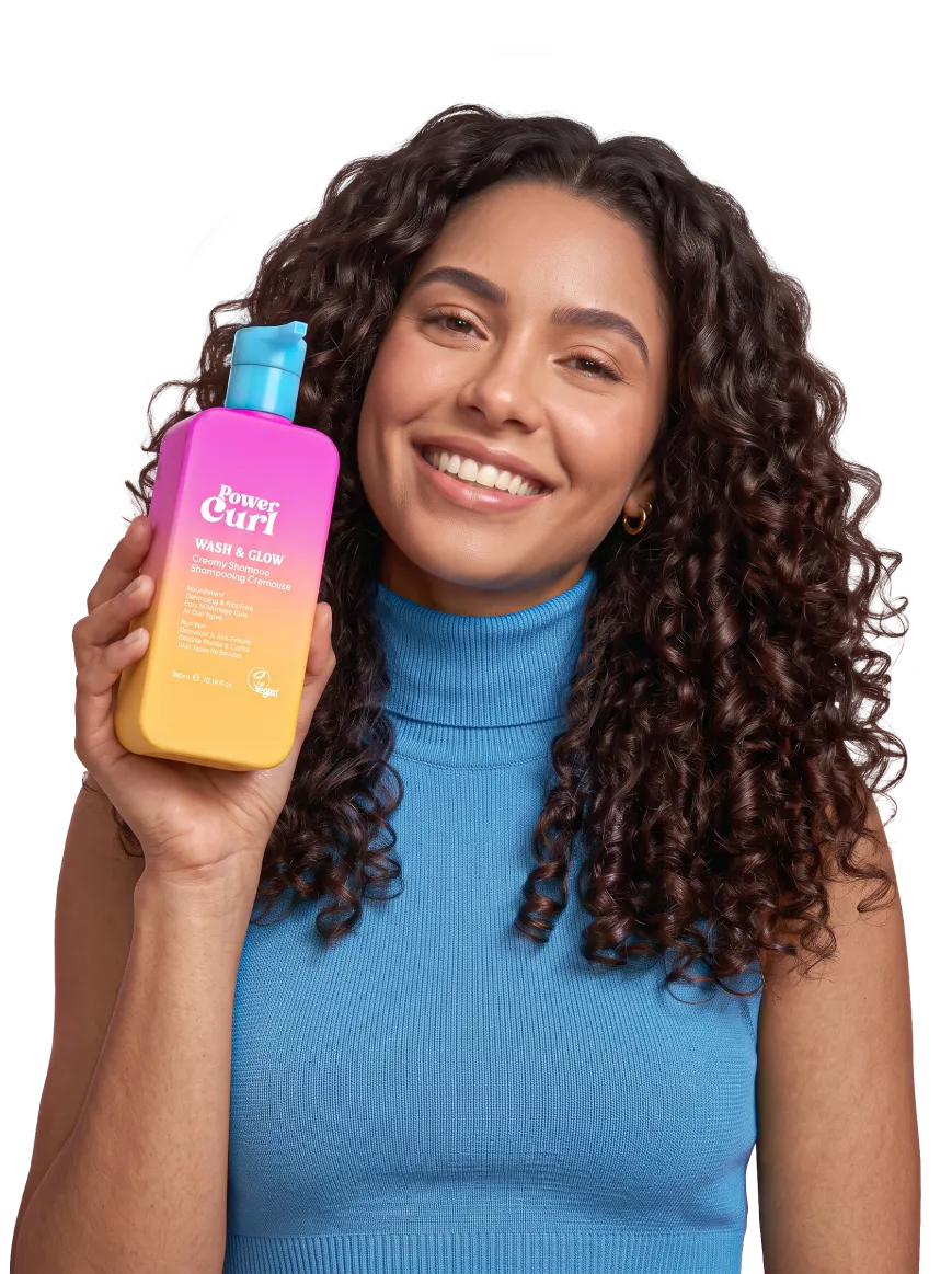 Woman with curly hair holding Power Curl Wash & Glow shampoo